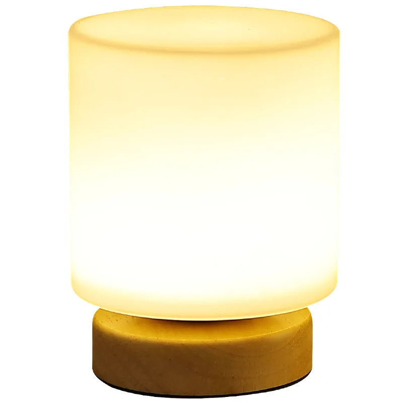 Nordic solid wood base USB table lamp with a white geometric shade on a wooden table.