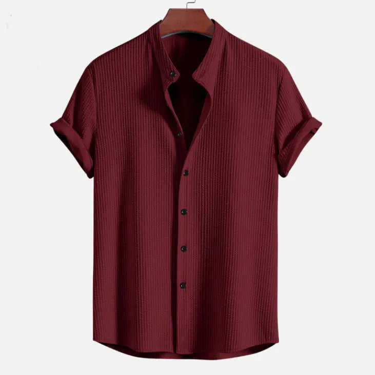 Man wearing a loose-fit short sleeve casual shirt in a solid colour, available in multiple sizes.