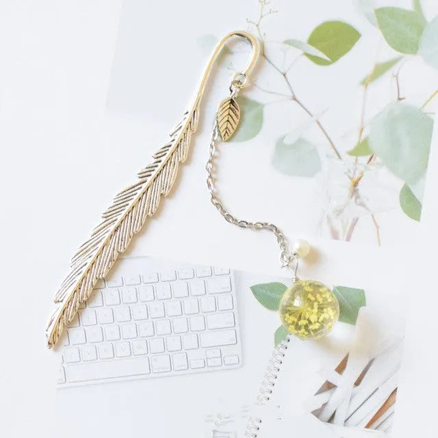 Dried flower specimen encased in metal alloy bookmark pendant measuring 12cm by 2cm