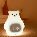 White silicone bear-shaped night light with a remote control on a wooden surface.