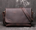 Men's vintage brown cowhide medium messenger bag showing front flap and long shoulder strap.