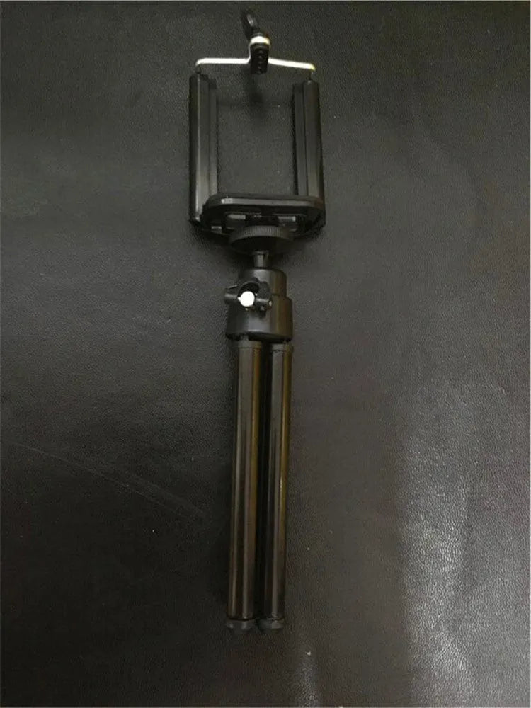 Black and silver desktop phone holder with a two-section adjustable bracket on a wooden desk.