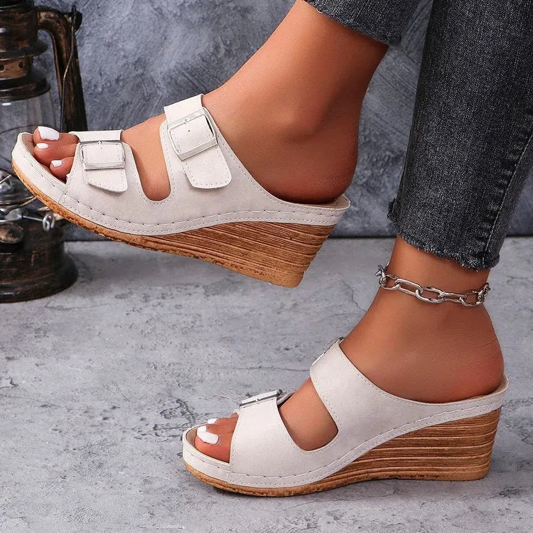 Women's creamy-white wedge sandals with a decorative outer belt buckle on the PU upper and a rubber sole.