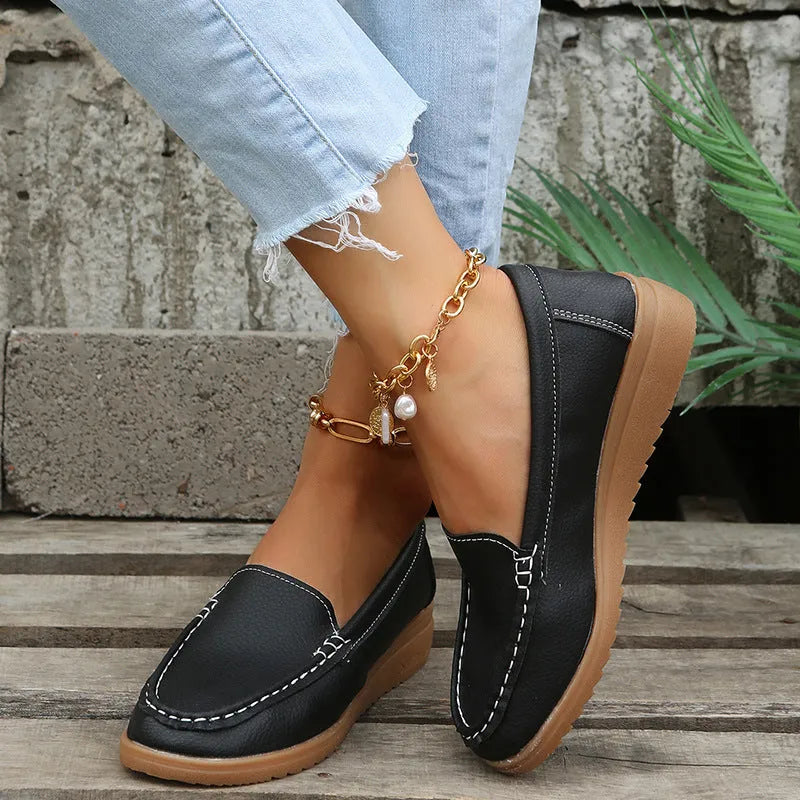 Women's flat slip-on loafers in PU leather with car suture detail, shown in multiple colours.