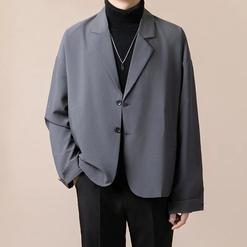 Men's loose fit light business style suit jacket in a polyester blend fabric, shown on a hanger.