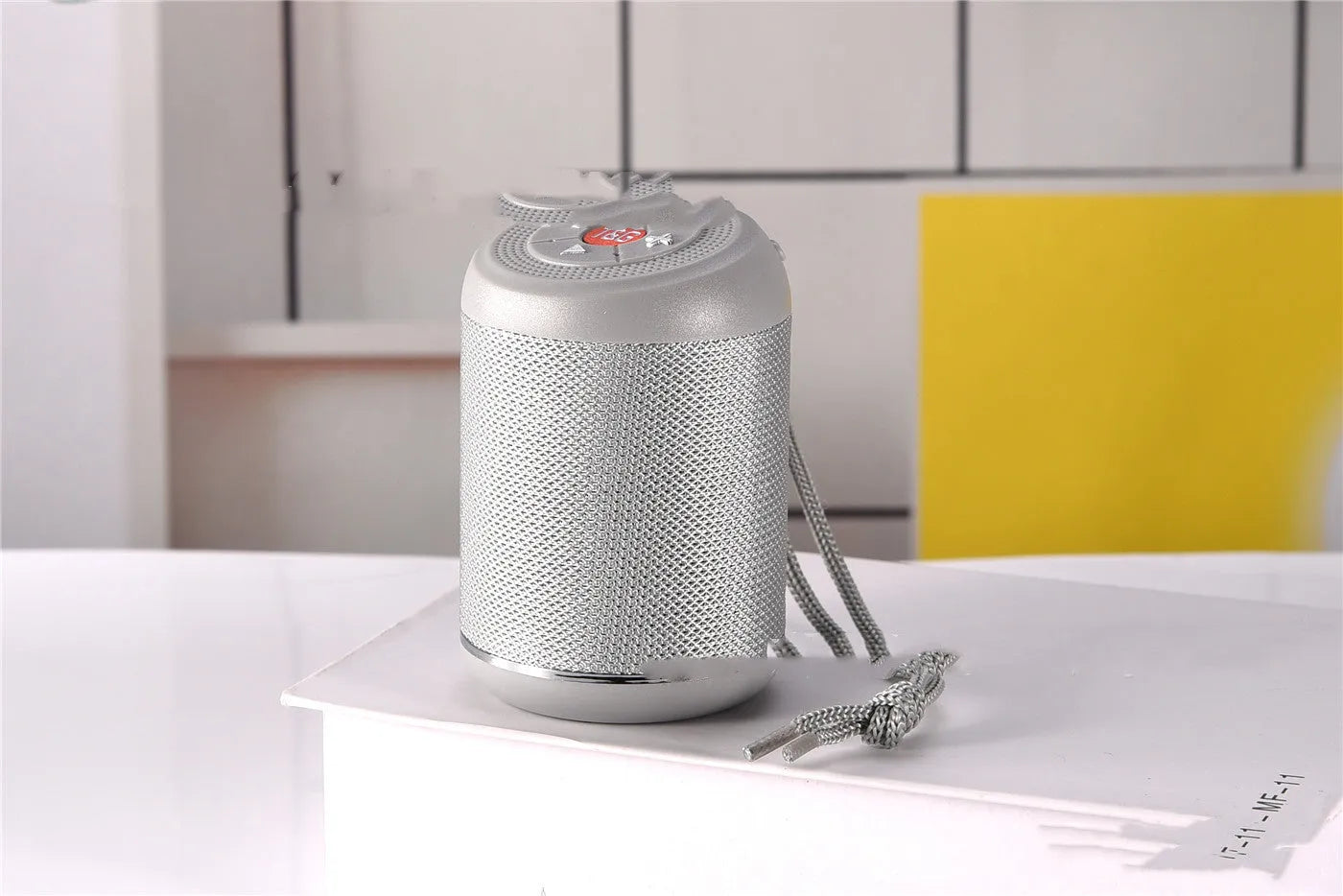 Portable outdoor Bluetooth subwoofer in multiple colours showing button controls for radio and playback functions.