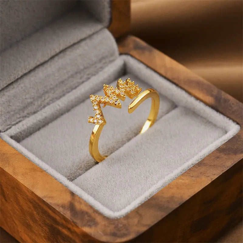 Gold geometric open fashion ring for women on a plain background.