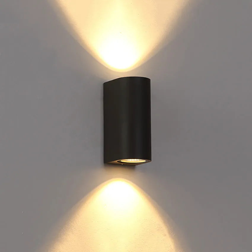 Modern black wall lamp with aluminium body, clear glass shade, and silicone rubber accents.