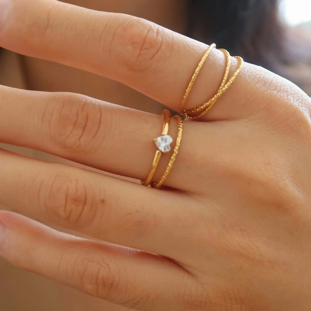 Golden stainless steel ring with heart shape or oval design on female hand