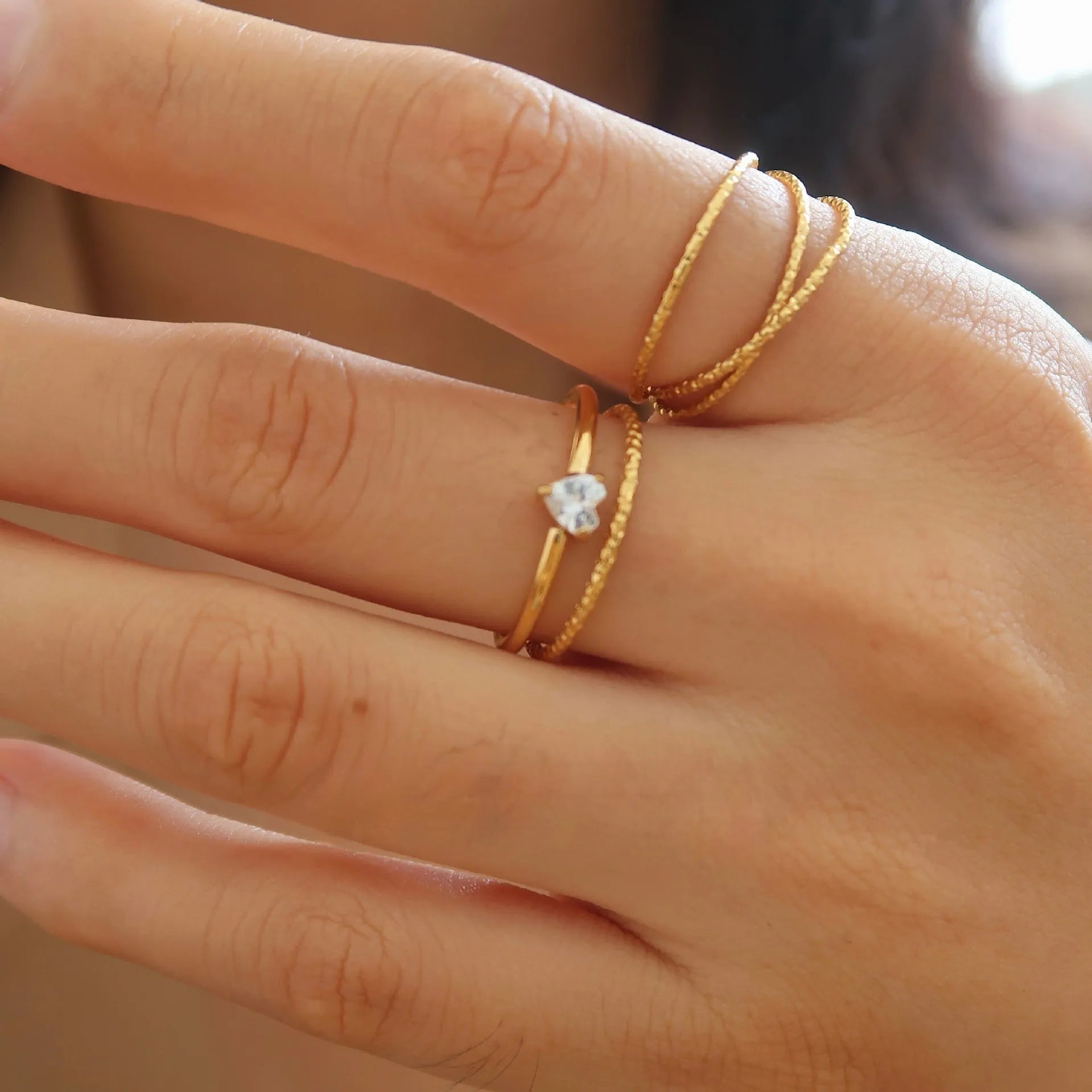 Golden stainless steel ring with heart shape or oval design on female hand