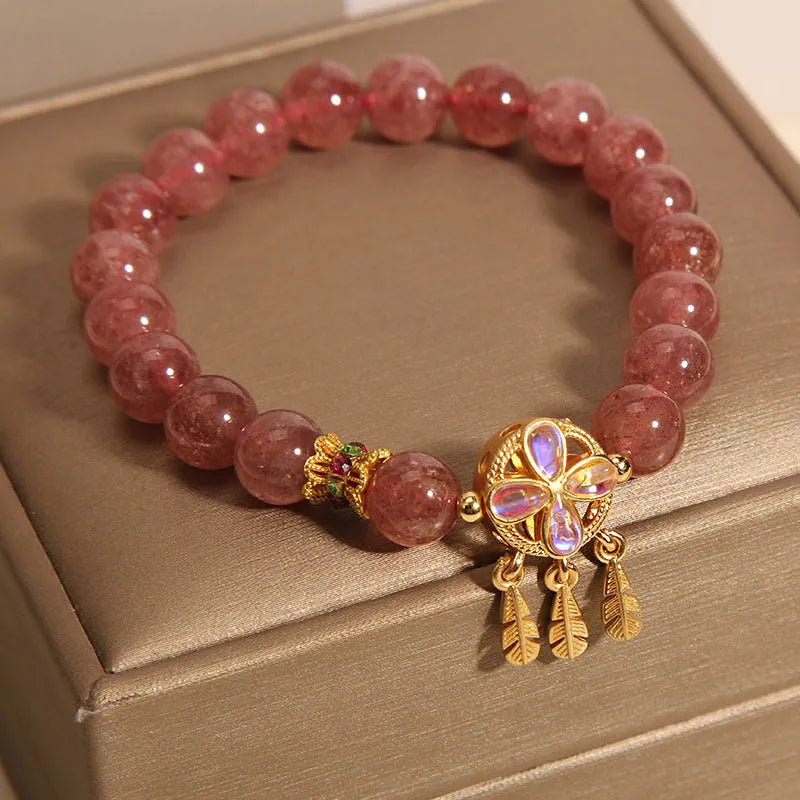 Women's strawberry quartz crystal bracelet with four leaf dream catcher pendant.