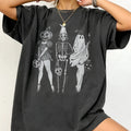 A loose-fitting black cotton T-shirt with short sleeves and a round neck on a hanger.