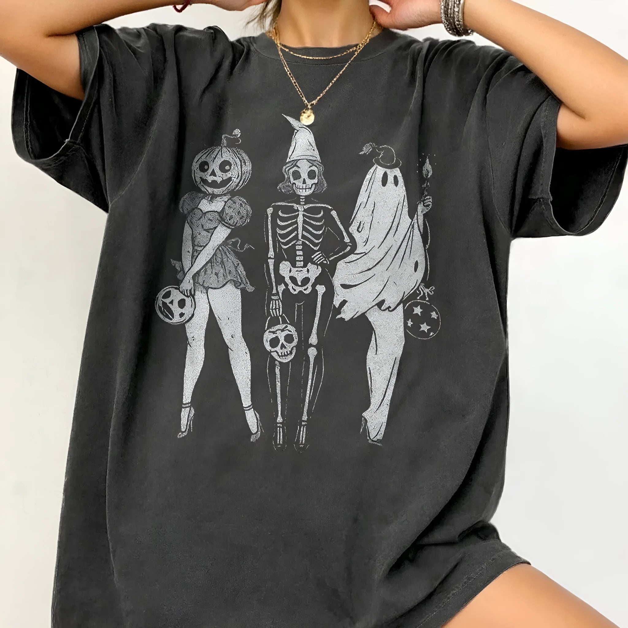 A loose-fitting black cotton T-shirt with short sleeves and a round neck on a hanger.
