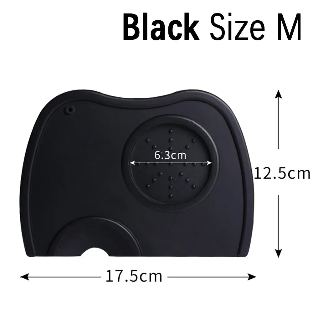 Black silicone pad coffee tamper with stainless steel base next to a red version on a counter.
