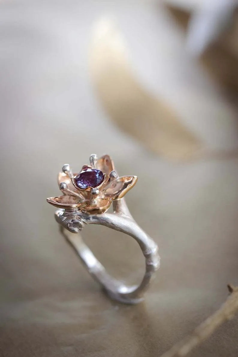 Silver two-tone floral design women's alloy ring on a simple geometric band.