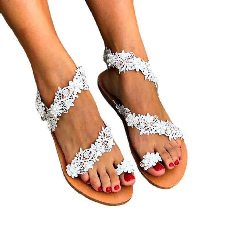 White women's flat sandals with rhinestone flower decoration and patent leather finish