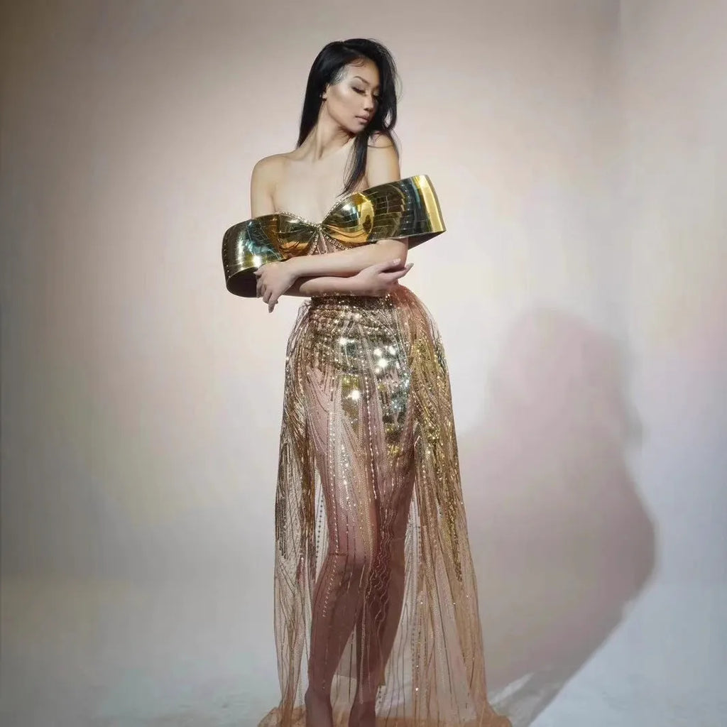 Gold strapless long dress with sequined tulle skirt and high side split, worn as formal evening wear.