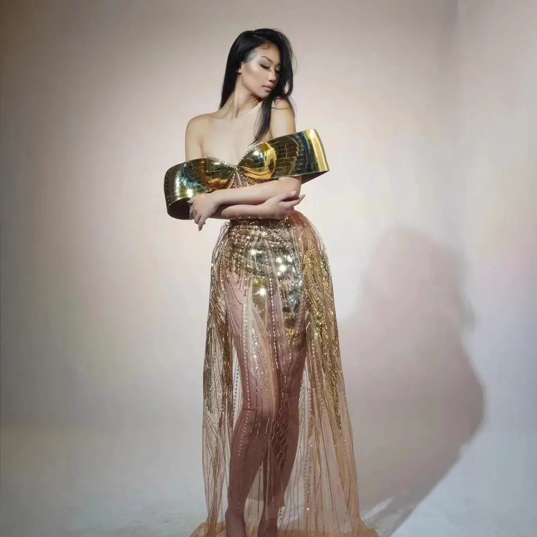 Gold strapless long dress with sequined tulle skirt and high side split, worn as formal evening wear.