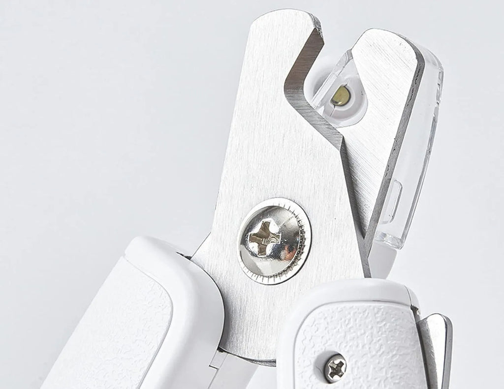 White LED pet nail clipper with a triangular blade, anti-splash guard, and leatherette handle.