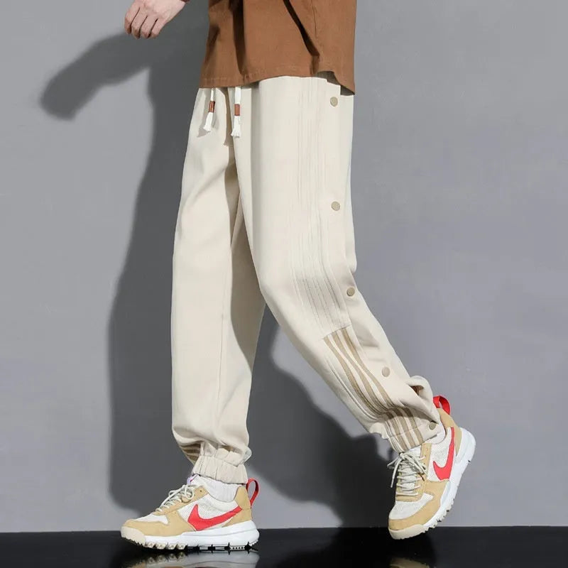 Man wearing loose grey sweatpants with ankle ties and a high waist.