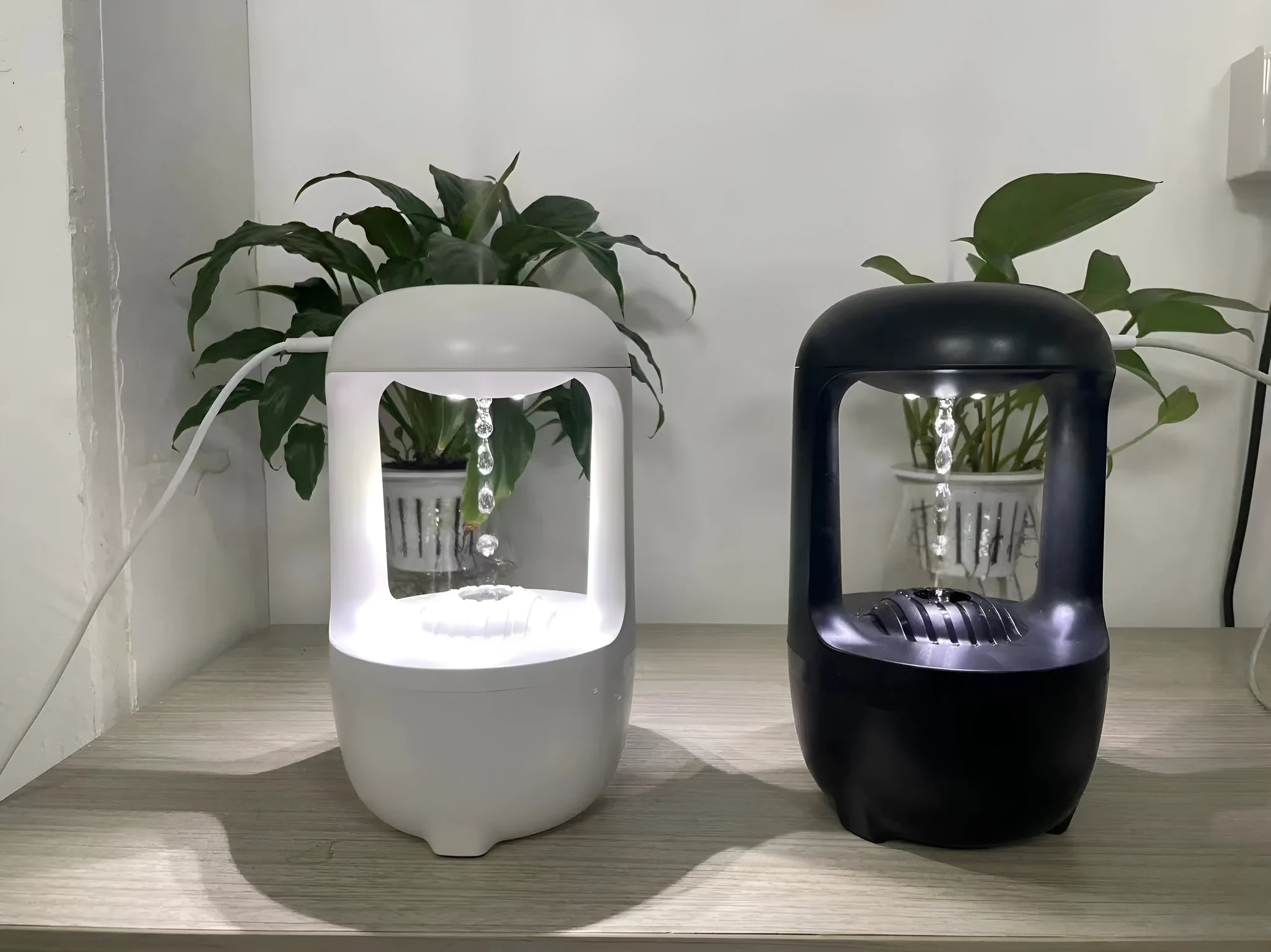 White anti-gravity humidifier showing floating water droplets on a desk next to a USB cable.