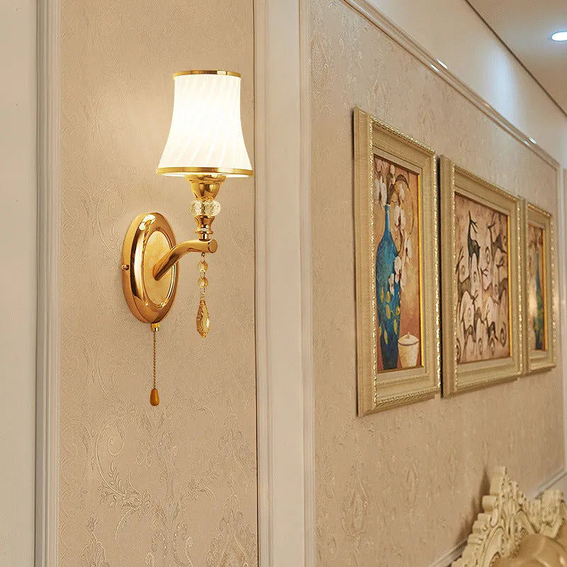 European style glass wall lamp with a fabric cable switch, shown in a bedroom setting.