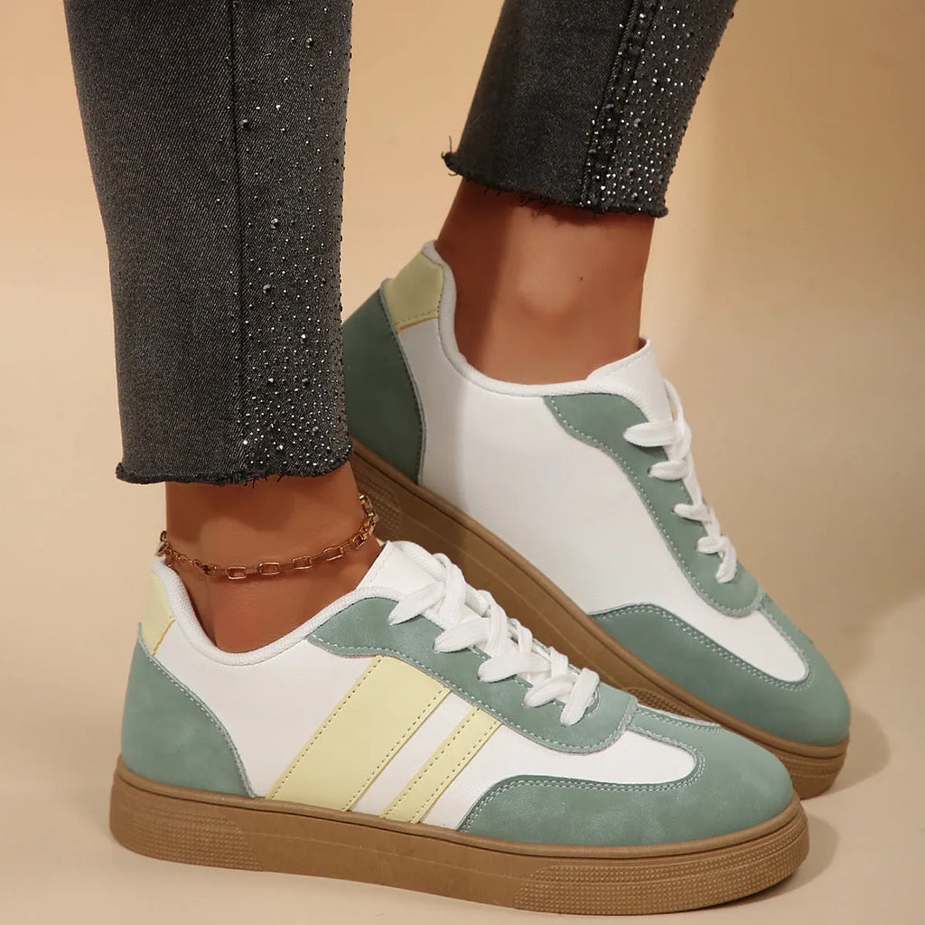 Green retro sports women's pumps with cross straps, leather stitching, round toe, and a low flat rubber sole.