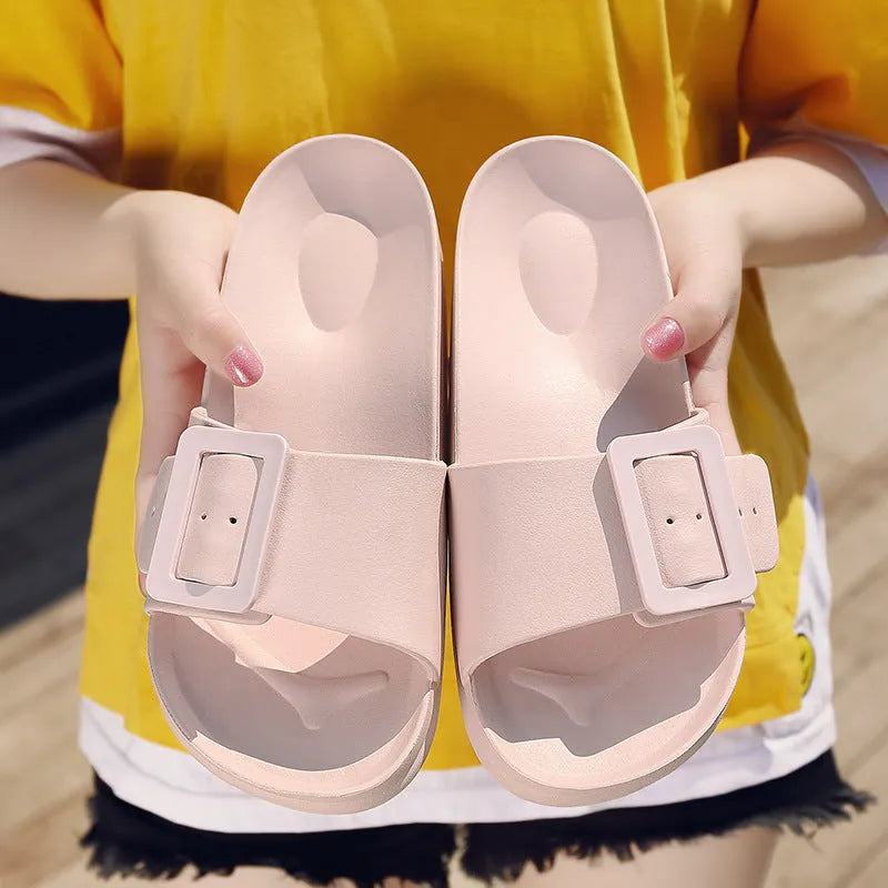 Women's grey blue buckle flip flops with a soft EVA sole on a plain background