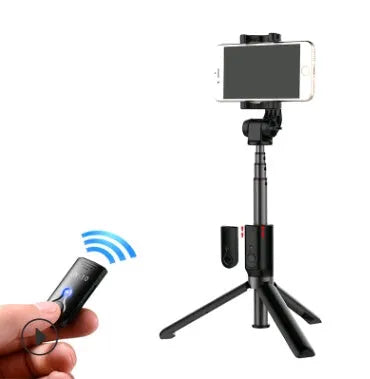 Aluminium Bluetooth selfie stick with tripod legs extended and wireless remote on a table