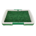 Green synthetic turf dog toilet tray with a plastic base for indoor puppy potty training.