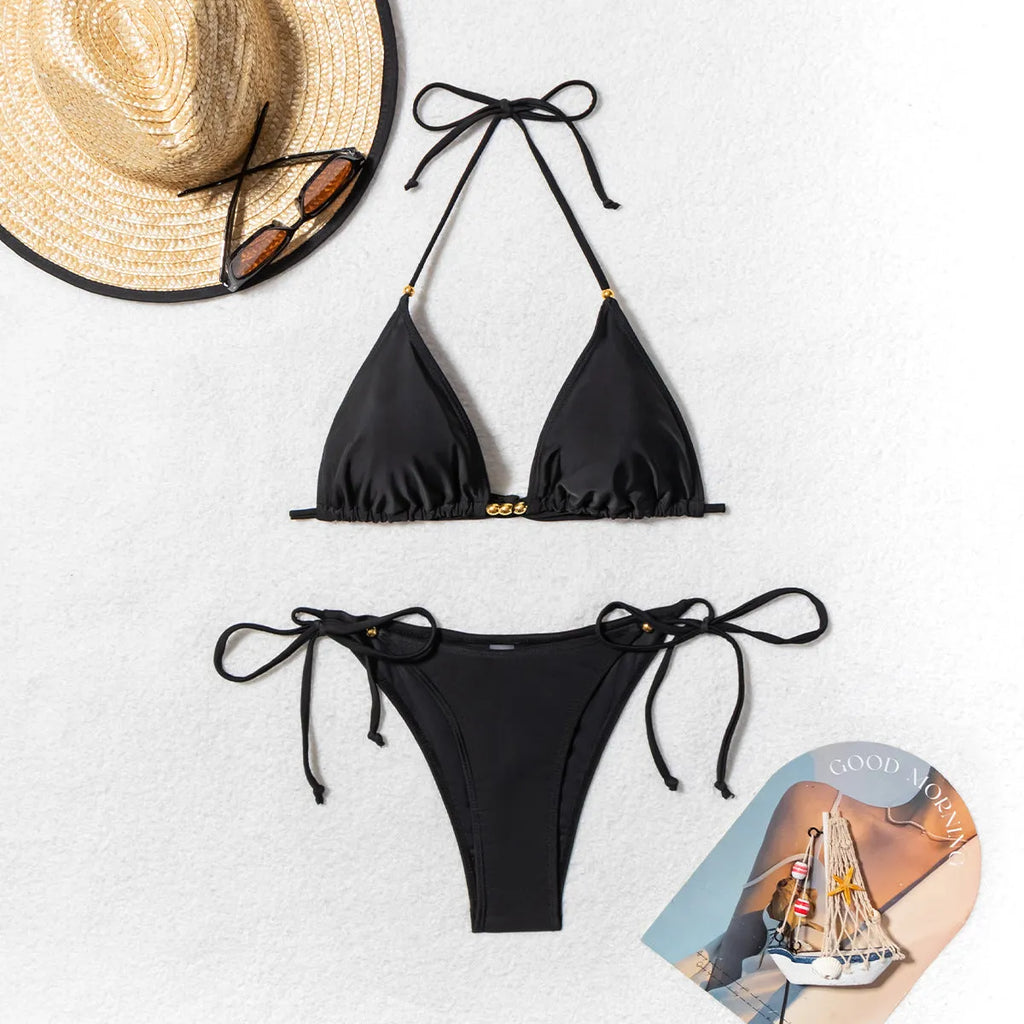 Black women's bikini swimsuit with metal bead detail on the split design.