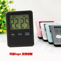Black and white mechanical kitchen timer with magnetic back showing 60-minute dial.