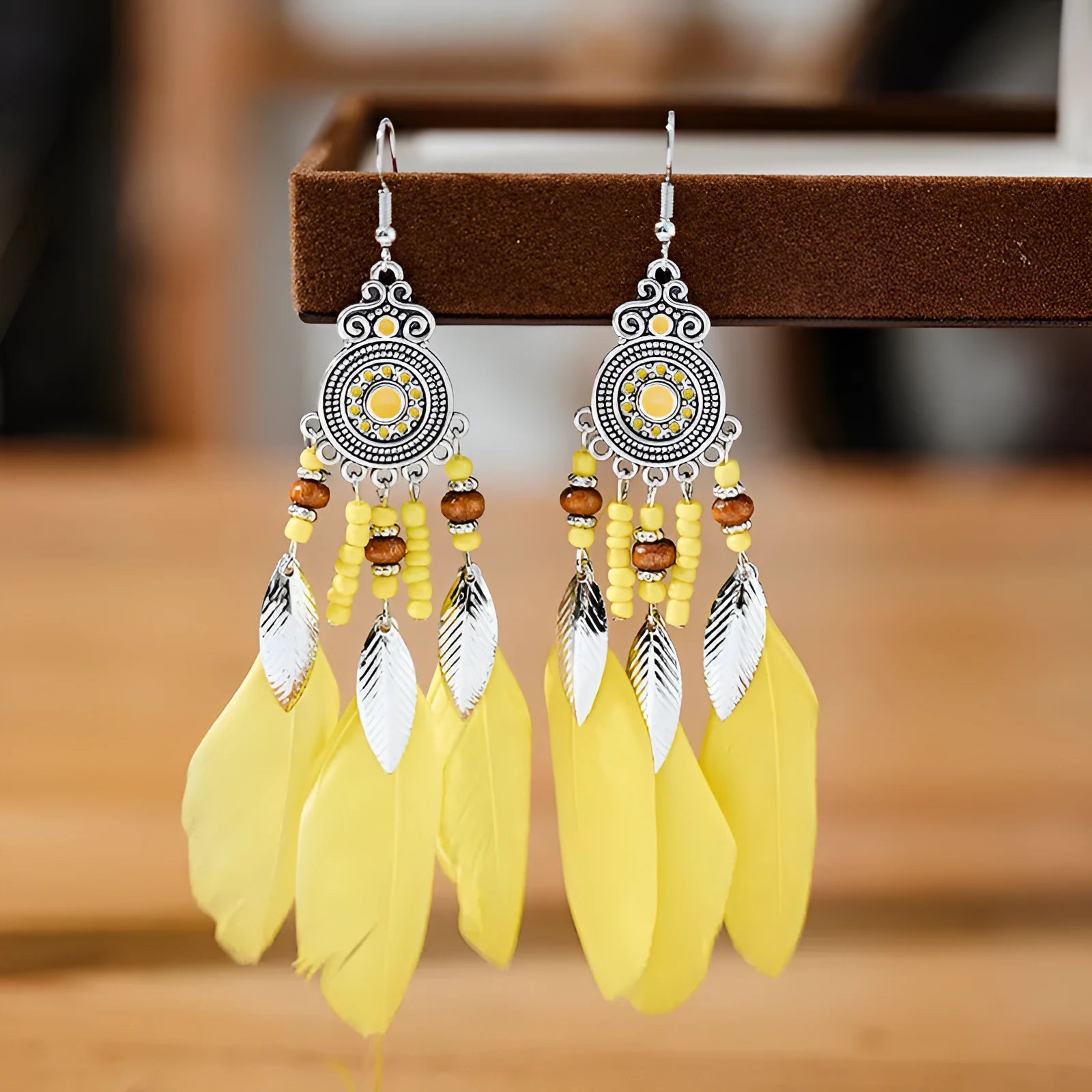 Round drop feather earrings with leaf patterning in alloy, available in multiple electroplated colours.