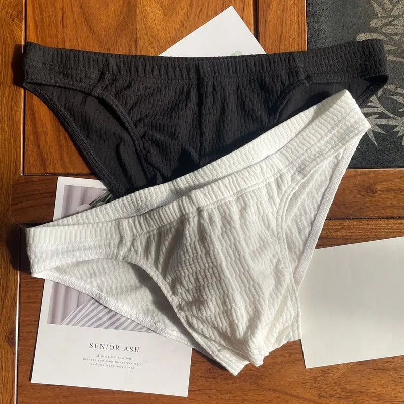 Men's solid colour cotton triangle briefs in apricot, shown from the front on a mid-waist fit model.