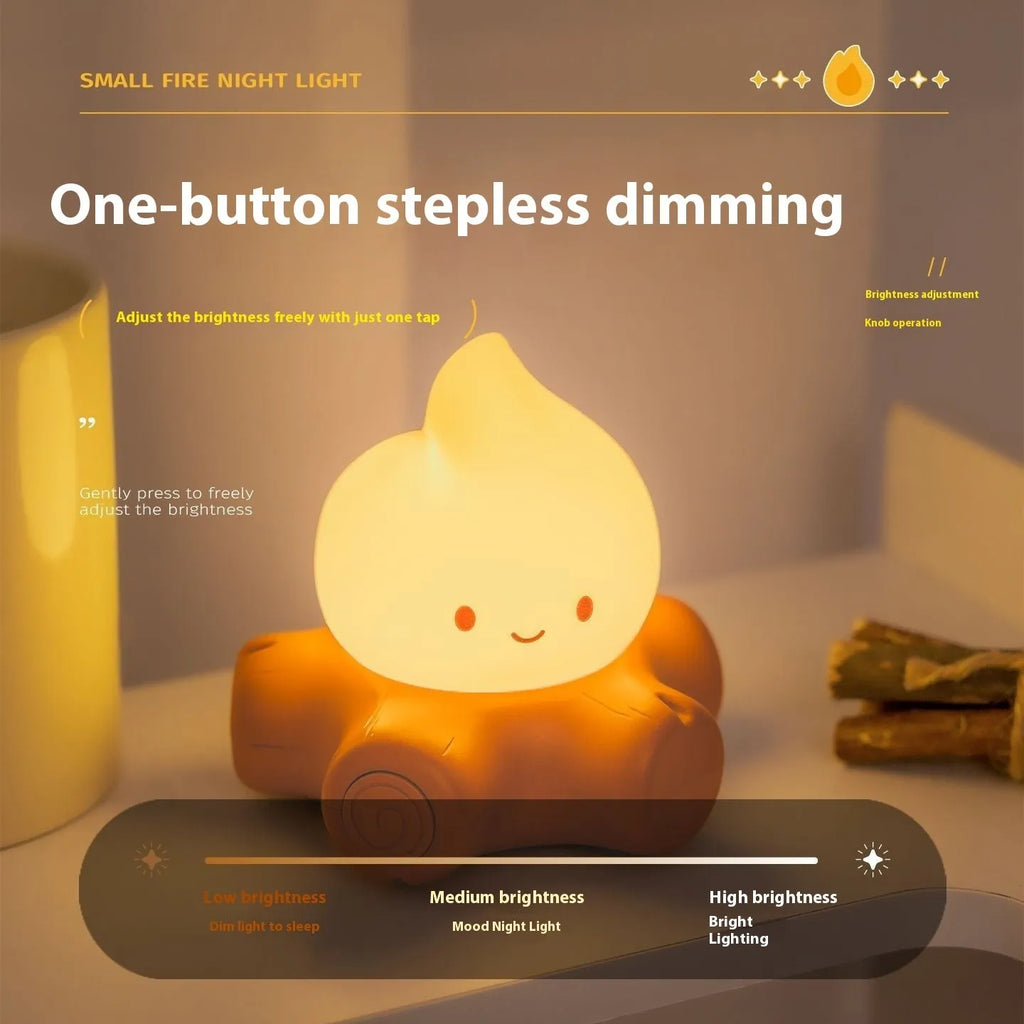 Cartoon small fire pile silicone night lamp with ABS shade on a wooden surface.