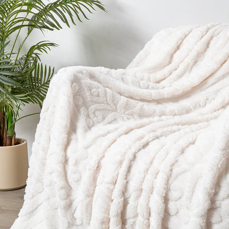 Shu cotton velvet jacquard sofa blanket with plant flower pattern in solid colour on a grey sofa.