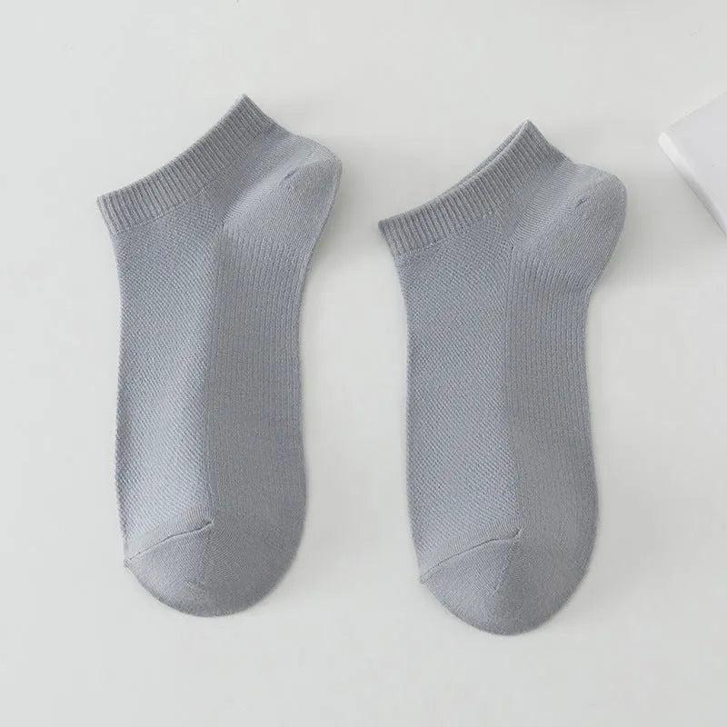 A pair of solid colour low-cut polyester boat socks for men, shown in one of six available colours.