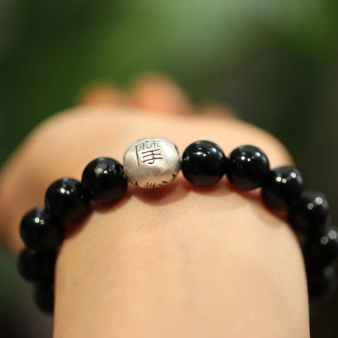 Natural black agate beaded bracelet with sterling silver clasp showing Chinese style threading