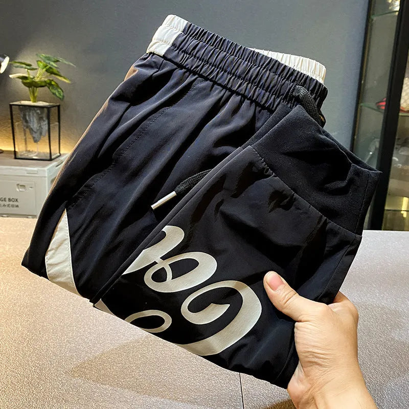 Men's black cropped casual trousers with an ankle band made from thin cotton fabric.