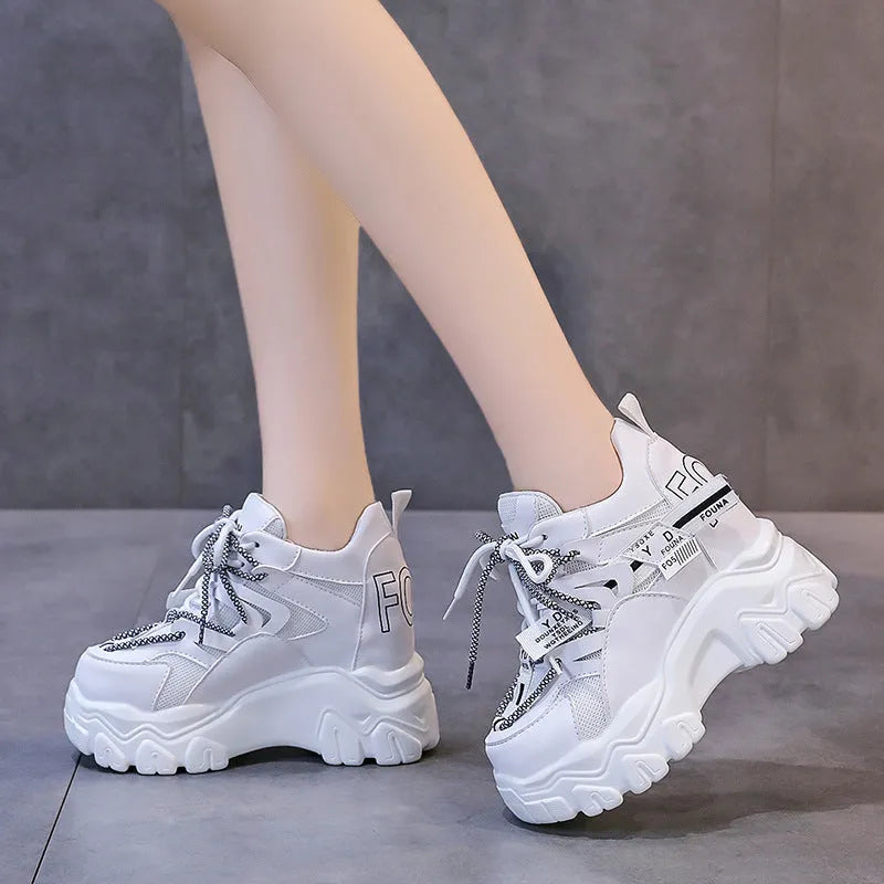 Women's white mesh platform sports shoes with cross strap and a high rubber sole.