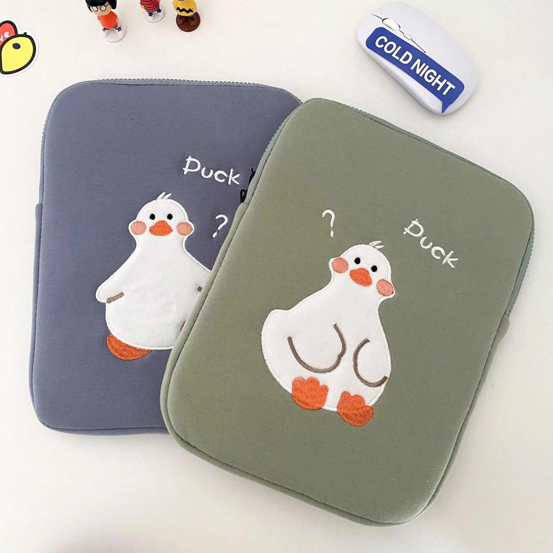 Blue cotton tablet case with embroidered cartoon duck design, zipper closed.