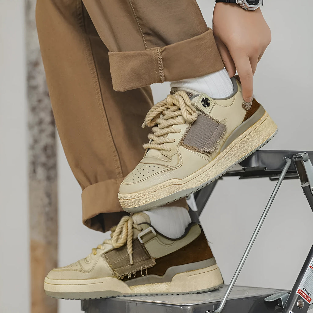 Beige low-top skateboard shoes with round toe and front lace-up closure on a flat rubber sole.