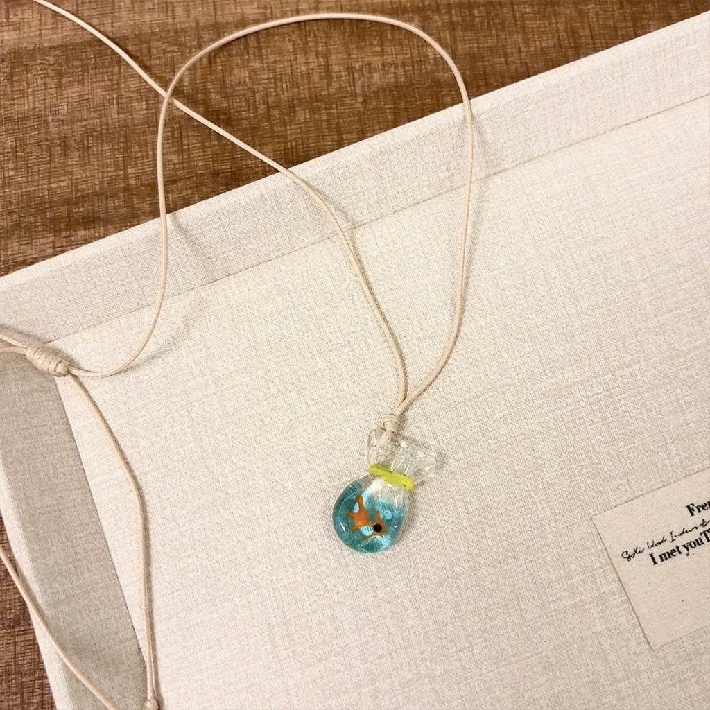 Women's necklace with a coloured glaze Small Fish Lucky Bag pendant on a cotton and linen clavicle chain.