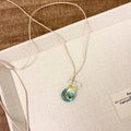 Women's necklace with a coloured glaze Small Fish Lucky Bag pendant on a cotton and linen clavicle chain.
