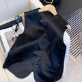 Black satin ladies' vest with loose fit and sleeveless design on hanger