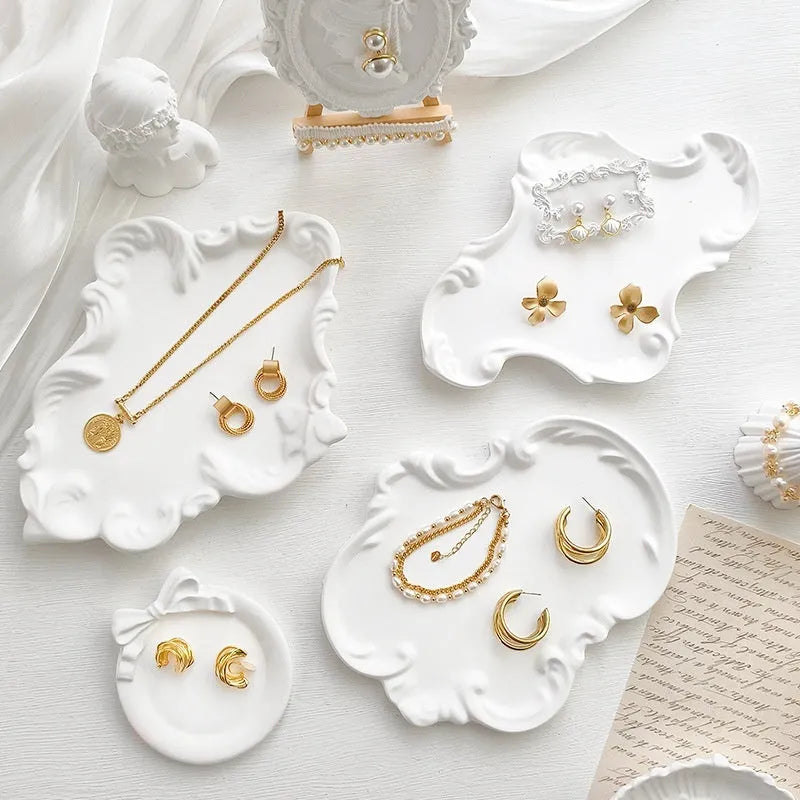 European Baroque style gypsum jewellery display plate with rings and earrings on a dressing table