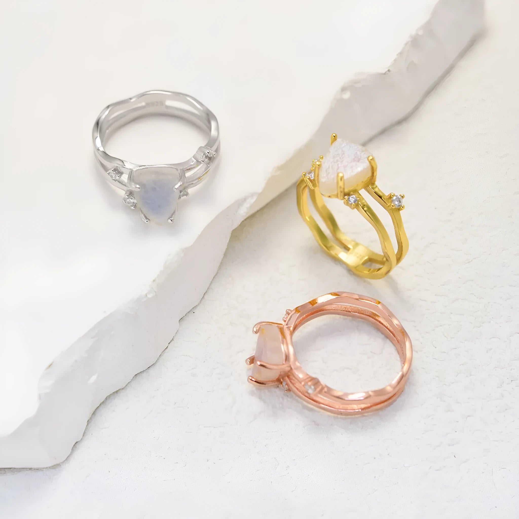 S925 sterling silver ring with irregular triangle shape holding a moonstone, shown in rose gold electroplated finish.