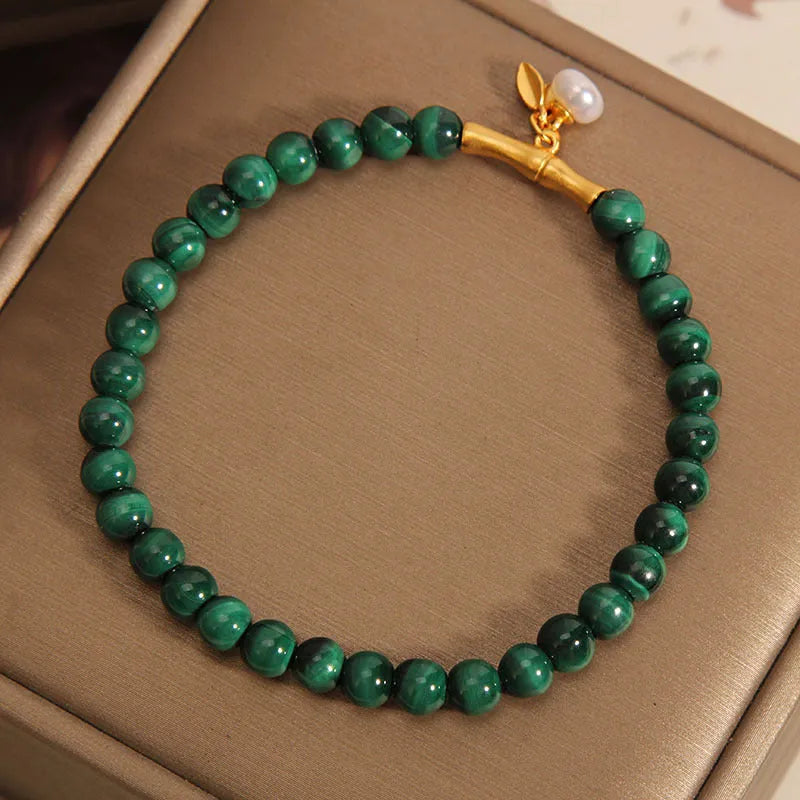 A women's adjustable bracelet made of white crystal with a lucky bamboo charm on the wrist.