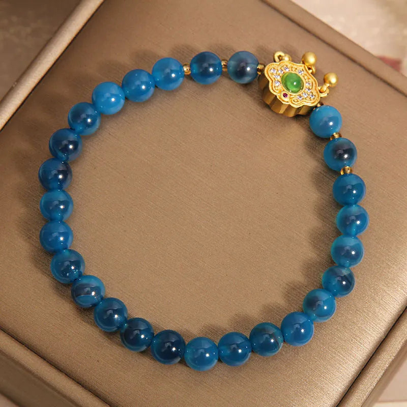 Blue sugar heart agate safety lock pendant on a crystal women's bracelet with alloy-set stones.