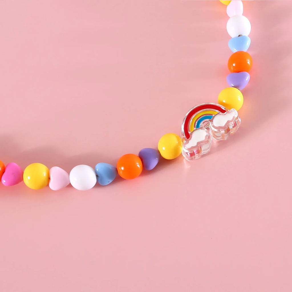 Colourful plastic bead cat necklace in rainbow, peach, or small flower pattern on a white background.